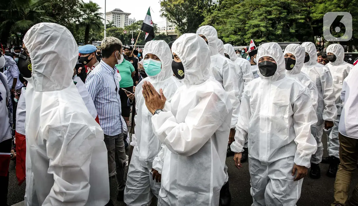 Petugas Satgas COVID-19 dari personel kepolisian menjaga protokol kesehatan peserta aksi solidaritas untuk Palestina di depan Kedutaan Besar Amerika Serikat, Jakarta, Selasa (18/5/2021). Massa mengutuk dan mengecam keras kekerasan yang dilakukan Israel atas Palestina. (Liputan6.com/Faizal Fanani)