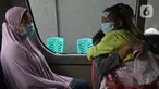 Warga berada di dalam mobil ambulans saat akan dibawa ke wisma atlet di Jalan As-Syafiiyah, Cipayung, Jakarta, Jumat (21/5/2021). Klaster Halal Bihalal di Cipayung bertambah 32 orang dari 51 orang menjadi 83 orang terpapar COVID-19 perhari ini. (Liputan6.com/Herman Zakharia)