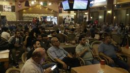 Warga Palestina menonton laga El Clasico antara Barcelona melawan Real Madrid di Gaza City, Minggu (6/5/2018). Konflik perang tak menyurutkan fenomena El Clasico. (AFP/Mahmud Hams)