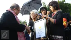 Jaya Suprana memberikan piagam kepada seorang wanita yang senantiasa melakukan Aksi Kamisan yang dilakukannya sejak tahun 2007, Jakarta, Kamis (19/1). (Liputan6.com/ Immanuel Antonius)
