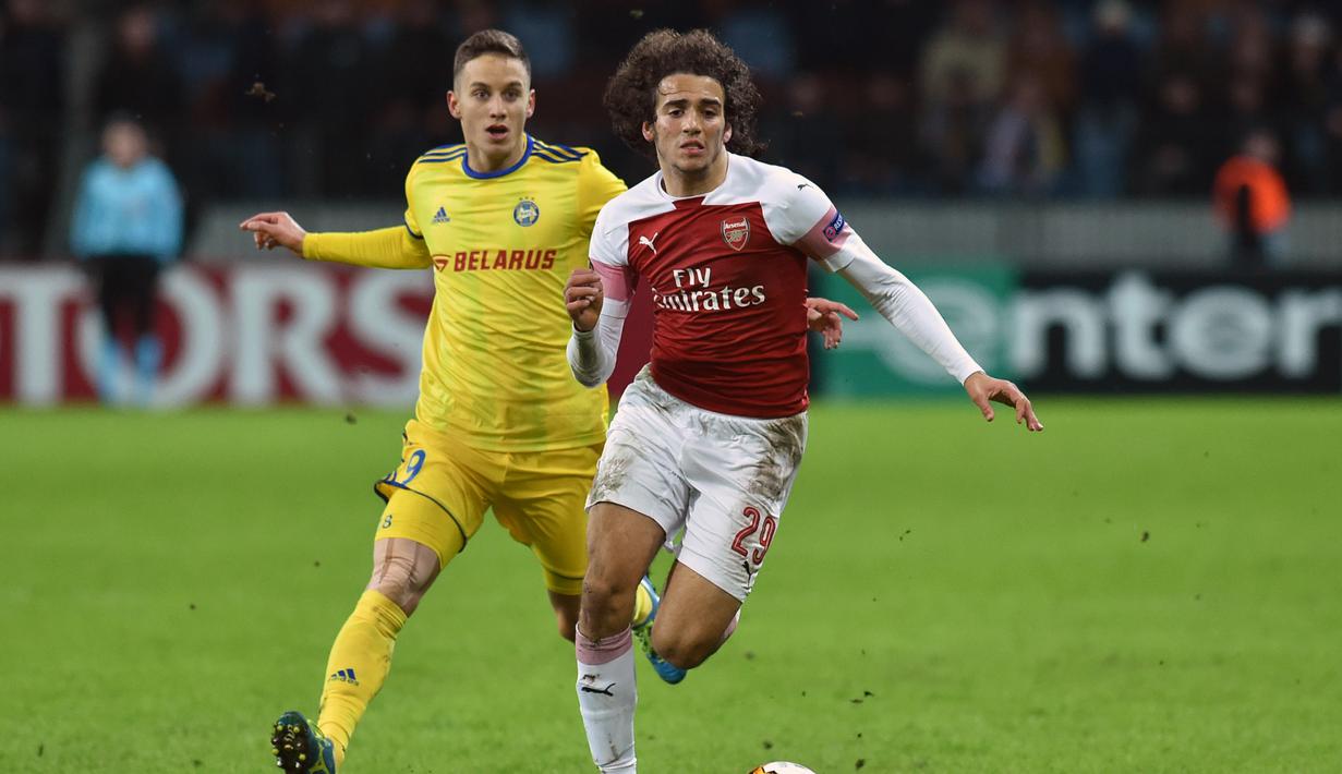 Aksi Matteo Guendouzi melewati pemain Bate Borisov, Bojan Dubajic pada leg 1,32 besar Liga Europa yang berlangsung di stadion Borisov Arena, Borisov, Jumat (15/2). Arsenal tumbang 0-1 kontra Bate Borisov. (AFP/Sergei Gapon)