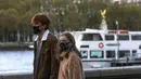 Sejumlah warga yang mengenakan masker berjalan di tepi Sungai Thames di London, Inggris (31/10/2020). Kasus baru COVID-19 di Inggris mencapai 21.915, menambah total kasus coronavirus di negara itu menjadi 1.011.660. (Xinhua/Han Yan)