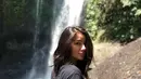 Perempuan berusia 30 tahun ini memang tetap terlihat memesona walaupun dengan gayanya yang santai. Berpose dengan latar belakang air terjun, ia tampak cantik menggunakan baju kaus hitam dengan rambut yang lurus. (Liputan6.com/IG/@itssheilamj)