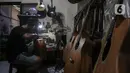 Harry saat mereparasi gitar klasik menjadi gitar listrik di toko kawasan Kedoya, Jakarta Barat, Selasa (9/2/2021). Selama pandemi COVID-19, servis gitar mengalami penurunan. (Liputan6.com/Johan Tallo)