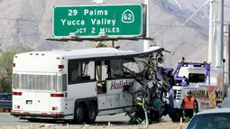 Petugas menderek sebuah bus pariwisata yang ringsek akibat bertabrakan dengan truk di Jalan Raya Southern California, Amerika Serikat, (23/10).  Kecelakaan tersebut terjadi pada pagi hari, dimana seluruh penumpang tengah tertidur. (REUTERS/Sam Mircovich)