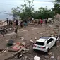 Orang-orang berjalan melewati mayat (penutup biru) setelah gempa dan tsunami di Palu, Sulawesi Tengah , Sabtu (29/9). Gelombang tsunami setinggi 1,5 meter yang menerjang Palu terjadi setelah gempa bumi mengguncang Palu dan Donggala. (AFP /OLA GONDRONK)