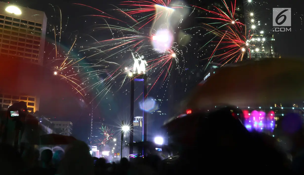 Kembang api menghiasi malam pergantian tahun baru 2019 di kawasan Bundaran HI, Jakarta, Selasa (1/1). Bundaran HI menjadi salah satu pilihan warga menikmati kembang api tahun baru. (Liputan6.com/Angga Yuniar)