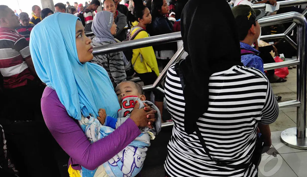 Seorang balita tampak tertidur digendongan ibunya di Stasiun Pasar Senen, Jakarta, Jumat (1/8/14). (Liputan6.com/Faizal Fanani)