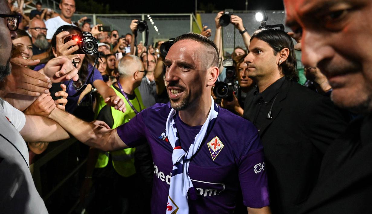 Rekrutan baru Fiorentina, Franck Ribery, menyapa suporter saat sesi perkenalan di Stadion Artemio Franchi, Florence, Kamis (22/8). Gelandang asal Prancis ini didatangkan secara gratis dari Bayern Munchen. (AFP/Andreas Solaro)