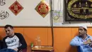 Para imigran Pakistan duduk usai menyantap makanan sahur untuk berpuasa di dalam sebuah restoran di distrik Kwai Chung, Hong Kong (25/5/2019). Luas wilayah kota ini 9,93 km². Area dalam Kwai Chung meliputi: Kwai Fong, Kwai Hing, Lai King, Tai Wo Hau. (AFP Photo/Philip Fong)