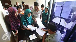 Petugas memanggil warga yang ingin membuat akte kelahiran dan e-KTP di Jakarta Timur, Senin (28/12). Proses pengurusan yang lebih mudah membuat warga membuat akte dan e-KTP jelang pergantian tahun. (Liputan6.com/Immnuel Antonius)