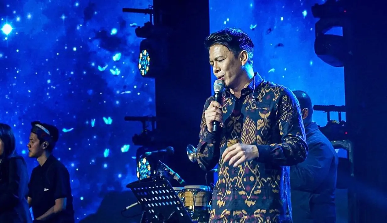 Ariel bikin penggemar makin jatuh hati dengan penampilan yang jarang ia perlihatkan di muka publik. Vokalis band NOAH ini tampil gagah dengan memakai batik saat manggung. Penampilannya itu pun langsung jadi pembicaraan di kalangan fans. Auranya makin memukau penonton yang hadir. (Liputan6.com/IG/@noah_site)