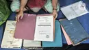 Salah seorang korban kebakaran menunjukkan surat-surat yang berhasil diselamatkan di salah satu kelas SMP PGRI 32, Cideng, Jakarta, Minggu (8/11/2020). Kebakaran menyebabkan seluruh barang milik warga hangus sekejap, kecuali surat-surat yang dapat terselamatkan. (merdeka.com/Iqbal Septian Nugroho)
