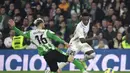 Bek Real Betis, German Pezzella (Kiri) berusaha merebut bola dari penyerang Real Madrid, Vinicius Junior selama pertandingan La Liga Spanyol di stadion Benito Villamarin di Seville, Senin (6/3/2023). Real Madrid bermain imbang dengan Real Betis dengan skor 0-0. (AFP/CRISTINA QUICLER)