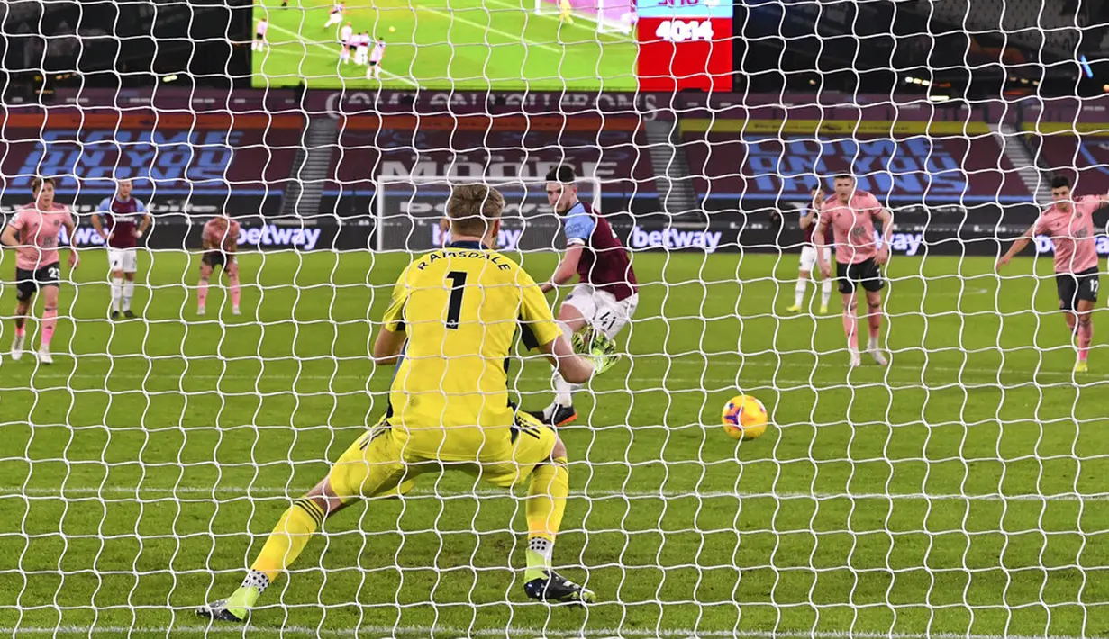 Pemain West Ham United Declan Rice menendang penalti ke gawang Sheffield United pada pertandingan Liga Inggris di London Stadium, London, Inggris, Senin (15/2/2021). West Ham United menang 3-0. (Justin Setterfield/Pool via AP )