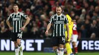 Pemain Manchester United (MU), Jonny Evans dan Christian Eriksen, tampak lesu setelah The Red Devils kebobolan gol pertama Nottingham Forest dalam pertandingan pekan ke-20 Liga Inggris 2023/2024 di The City Ground, Nottingham, Minggu (31/12/2023) dini hari WIB. MU kalah 1-2 dalam laga ini. (Darren Staples / AFP)