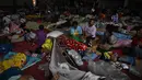 Imbas baku tembak antara militer Thailand dan Kamboja di wilayah sengketa perbatasan kedua negara pada Kamis pagi (24/7/2025), ratusan orang termasuk anak-anak dan orang tua mengungsi sementara di salah satu aula Universitas Surindra Rajabhat, di provinsi perbatasan Thailand, Surin. (Lillian SUWANRUMPHA/AFP)