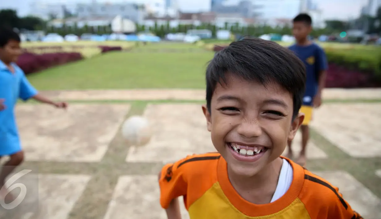 Sejumlah anak bermain bola di Tugu Tani, Jakarta, Jumat (2/10/2015). Pemprov DKI Jakarta akan menambah ruang publik terpadu ramah anak (RPTRA) sebanyak 150 lokasi dengan menggunakan dana dari program CSR.(Liputan6.com/Faizal Fanani)