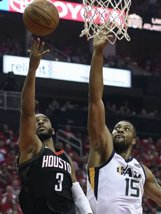 Aksi pemain Houston Rockets, Chris Paul (3) melakukan tembakan melewati pemain Utah Jazz, Derrick Favors pada playoff game kedua NBA basketball di Toyota Center, Houston, (2/5/2018). Utah Jazz menang 116-108. (AP/Eric Christian Smith)