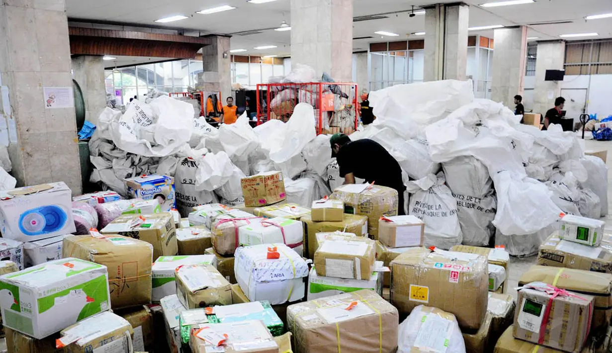 Petugas menata paket kiriman yang baru tiba di Kantor Pos Pasar Baru, Jakarta, Selasa (1/7/14). (Liputan6.com/Faizal Fanani)