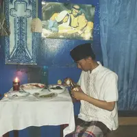 Jangan dulu menilai buruk, cobalah tengok kisah nyata dari pria berpeci yang tengah duduk di bawah lukisan Yesus ini.  (Foto: Facebook/Agung Rangkuti Zayadi)