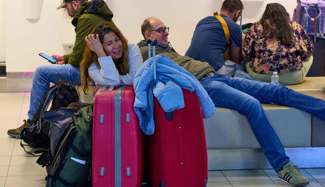 Pembatalan jadwal penerbangan akibat landasan pacu yang tertutup salju dan proses de-icing pesawat yang terhambat. Tampak dalam foto, para pelancong yang terlantar menunggu di bandara Schiphol di Amsterdam, Belanda, Rabu 7 Januari 2026. (AP Photo/Peter Dejong)