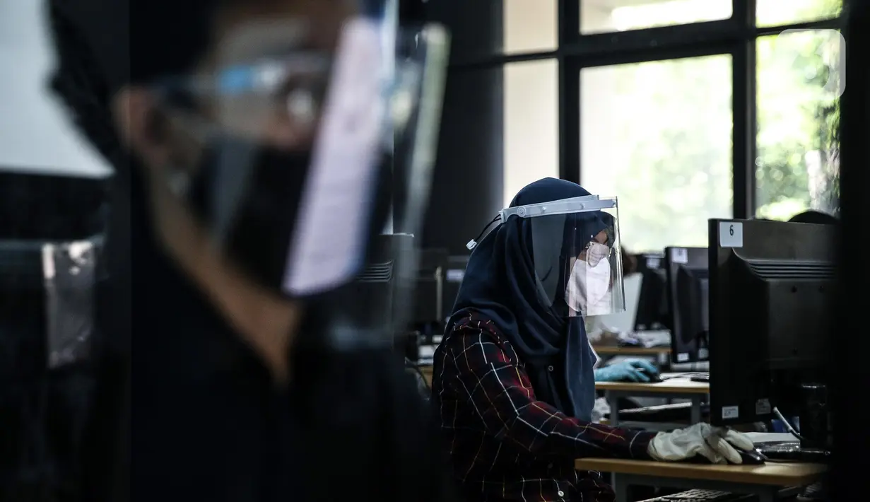 Peserta mengenakan masker, pelindung wajah, dan sarung tangan saat mengikuti Seleksi Bersama Masuk Perguruan Tinggi Negeri (SBMPTN) di Universitan Negeri Jakarta, Minggu (5/7/2020). Sebanyak 42.463 peserta mengikuti SBMPTN dengan prosedur protokol kesehatan. (Liputan6.com/Faizal Fanani)
