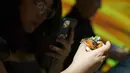 Seorang tamu mengambil gambar nugget dari daging ayam hasil rekayasa laboratorium selama presentasi media di Singapura pada Selasa (22/12/2020). Singapura menjadi negara pertama yang mengizinkan penjualan daging ayam yang tidak berasal dari hewan yang disembelih (Nicholas YEO / AFP)