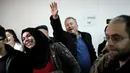 Ayah Ahed Tamimi, Bassem Tamimi mengangkat tangannya memberi dukungan kepada putrinya saat berada di pengadilan militer Israel di penjara Ofer, Israel (13/2). (AFP/Thomas Coex)
