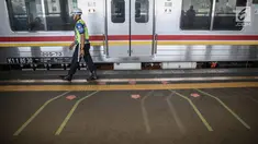 Petugas berjaga di garis antrean penumpang saat menunggu KRL di Stasiun Juanda, Jakarta, Kamis (10/8). PT KAI Commuter Jabodetabek melakukan uji coba garis antrean penumpang tersebut guna untuk keselamatan bagi para penumpang. (Liputan6.com/Faizal Fanani)