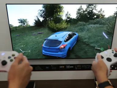 Model mencoba video game yang ditampilkan layar TV OLED LG di Jakarta (12/2021). PT LG Electronics Indonesia (LG) semakin gencar memperluas pemasaran TV OLED dengan menjangkau segmen untuk kebutuhan gaming, di antaranya dengan mengedepankan seri TV OLED C1. (Liputan6.com)