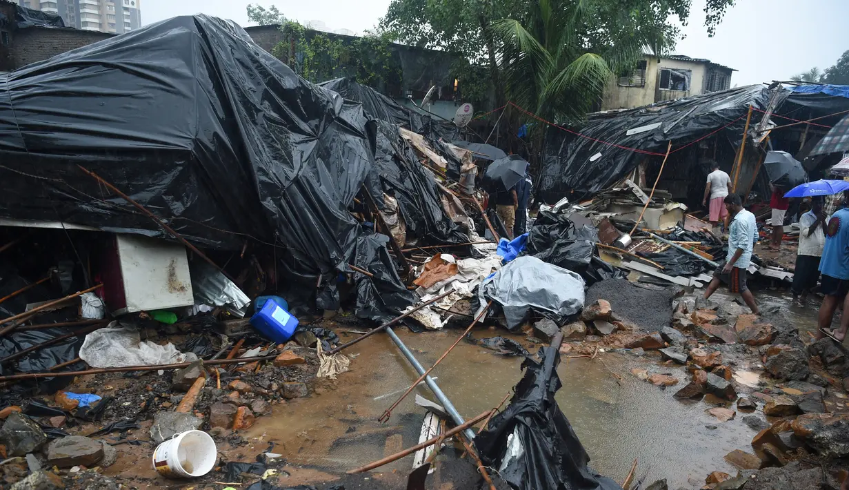 Petugas penyelamat dan warga mencari korban di lokasi runtuhnya tembok di Mumbai, India (2/7/2019). Sedikitnya 15 orang tewas dan 69 orang lainya luka ketika sebuah tembok runtuh saat hujan lebat monsun. (AFP Photo/Punit Paranjpe)