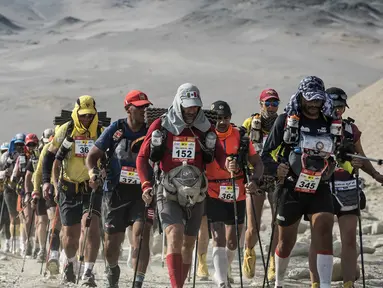 Para peserta berjalan saat mengikuti lomba marathon sejauh 250 kilometer di Gurun Ica, Kamis (30/11/2017). Marathon yang terbagi dalam enam tahapan ini diprediksi akan berakhir pada 4 Desember. (AFP/Jean-Philippe Ksiazek)