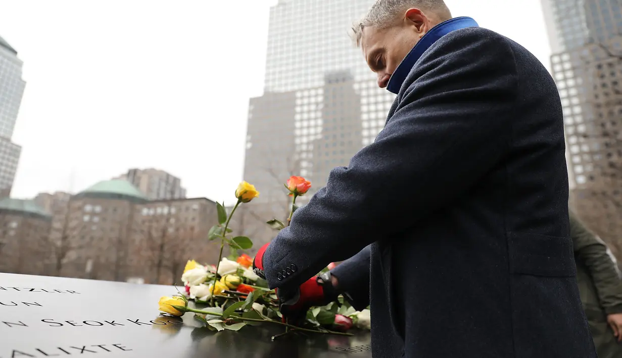 Seorang pria menaruh bunga mawar dalam peringatan 25 tahun serangan bom truk di WTC, New York City, Amerika Serikat, Senin (26/2). Pada tanggal 11 September 2001, WTC diserang kembali. (Spencer Platt/Getty Images/AFP)