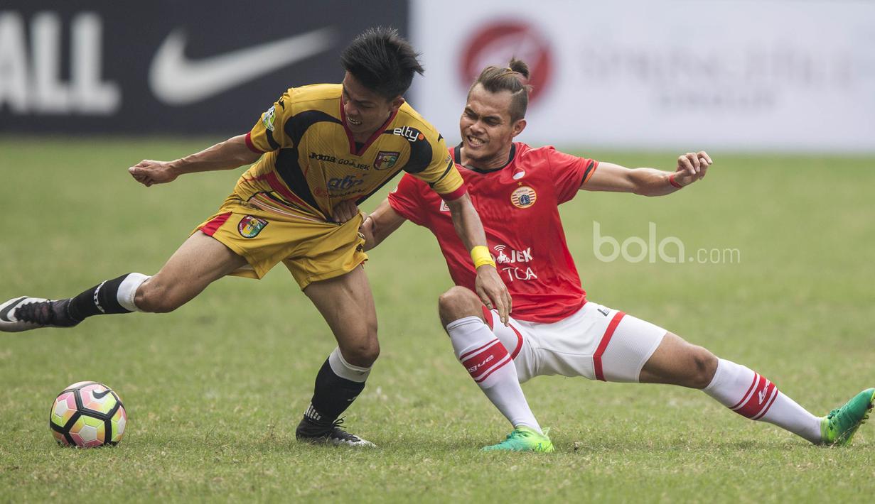 Gelandang Mitra Kukar, Yogi Rahadian, berebut bola dengan bek Persija, Rezaldi Hehanusa, pada laga Liga 1 di Stadion Patriot, Bekasi, Minggu (14/5/2017). Kedua tim bermain imbang 1-1. (Bola.com/Vitalis Yogi Trisna)