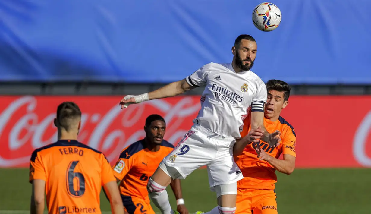 Striker Real Madrid, Karim Benzema, menyundul bola saat melawan Valencia pada laga Liga Spanyol di Stadion Alfredo Di Stefano, Minggu (14/2/2021). Real Madrid menang dengan skor 2-0. (AP/Manu Fernandez)