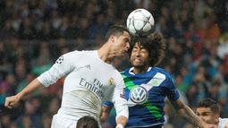 Striker Real Madrid, Cristiano Ronaldo, duel dengan bek Wolfsburg, Dante, pada leg kedua perempat final Liga Champions di Stadion Santiago Bernabeu, Madrid, Rabu (13/4/2016) dini hari WIB. (AFP/Curto De La Torre)