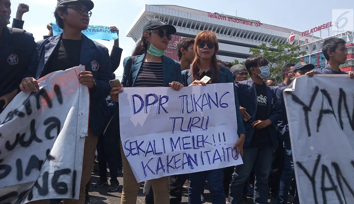 Mahasiswa membawa poster dalam unjuk rasa di Kantor Gubernur Jawa Tengah, Jalan Pahlawan Semarang, Selasa (24/9/2019). Mahasiswa dari berbagai universitas meneriakkan kecaman terhadap DPR sebagai protes terhadap rencana pengesahan Rancangan KUHP dan sejumlah RUU lain. (Liputan6.com/Gholib)