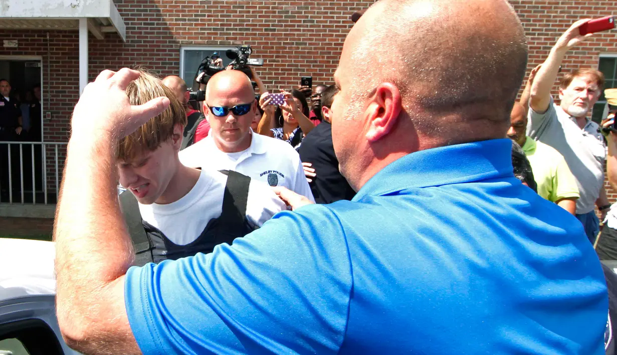 Polisi saat memasukkan Dylann Roof (21), terduga pelaku penembakan 9 orang di gereja Emanuel AME ke dalam sebuah kendaraan di Shelby  Carolina Selatan, Kamis (18/6/2015). (REUTERS/Jason Miczek)