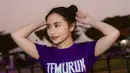 Tubuhnya semakin terlihat langsing ketika mengenakan kaos ungu lengan pendek dipadukan celana ketat warna senada. Rambutnya dicepol rapi. [@prillylatuconsina96]