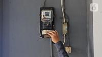 Warga memeriksa meteran listrik di kawasan Matraman, Jakarta. (Liputan6.com/Herman Zakharia).