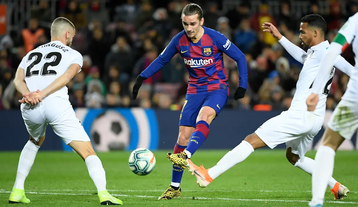 Penyerang Barcelona, Antoine Griezmann berebut bola dengan dengan bek Granada, Domingos Duarte pada lanjutan pertandingan La Liga Spanyol di Camp Nou, Minggu (19/1/2020). Barcelona sukses meraih kemenangan atas tamunya Granada dengan skor tipis 1-0. (LLUIS GENE / AFP)