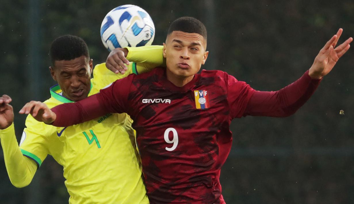 Pemain Timnas Brasil U-20, Robert Renan (kiri) berebut bola dengan pemain Timnas Venezuela U-20, Kevin Kelsy pada laga Piala Amerika Selatan U-20 di Metropolitano de Techo Stadium, Bogota, Kolombia (3/2/2023). Bek tengah berusia 19 tahun yang sejak Januari 2023 membela Zenit St Peterseburg ini memiliki nilai pasar 3 juta euro atau setara hampir Rp50 miliar. Bersama Timnas Brasil U-20 ia telah mengoleksi 11 caps sejak debut pada 11 Juni 2022. (AFP/Juan Pablo Pino)