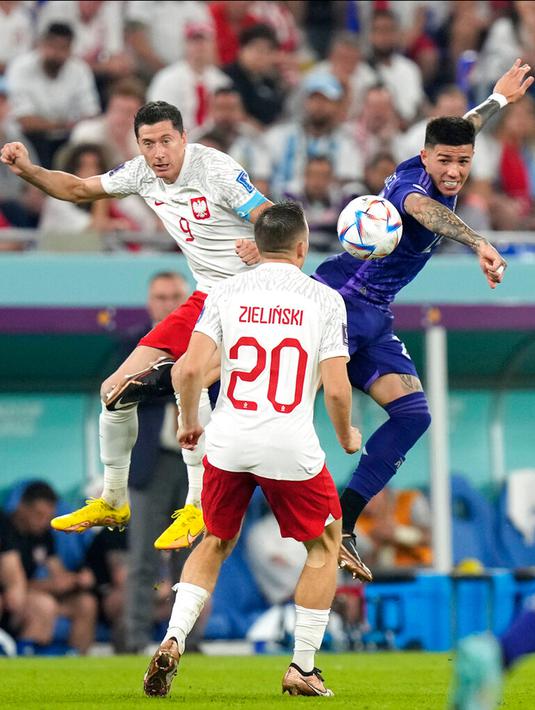 Pemain Polandia Robert Lewandowski (kiri) melompat untuk merebut bola dengan pemain Argentina Enzo Fernandez pada pertandingan sepak bola Grup C Piala Dunia 2022 di Stadion 974, Doha, Qatar, 30 November 2022. Argentina lolos ke babak 16 besar Piala Dunia 2022 dengan status juara Grup C usai mengalahkan Polandia 2-0. (AP Photo/Darko Bandic)