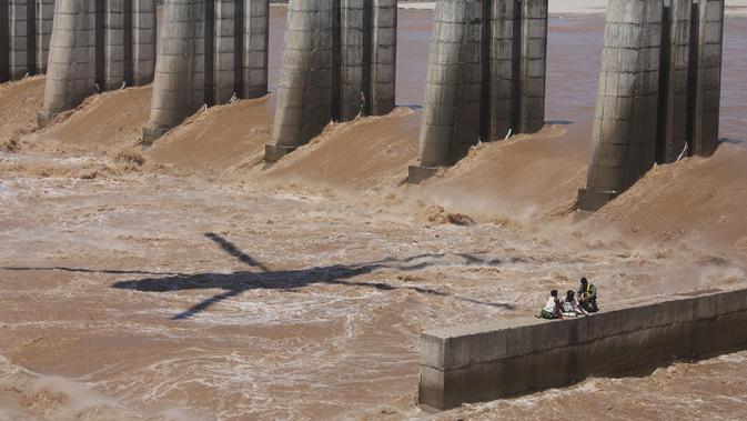 Seorang Angkatan Udara India bersiap  menyelamatkan dua di antara empat nelayan yang terperangkap dalam banjir di Sungai Tawi di Jammu, India (19/8/2019). Permukaan air di banyak sungai di India utara meningkat setelah hujan lebat di musim hujan. (AP Photo/Channi Anand)