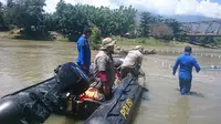 Petugas gebungan sedang mengamati keberadaan buaya berkalung ban target di Sungai Palu, Sabtu (8/2/2020). (Foto: Liputan6.com/Heri Susanto)