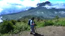 Seorang pendaki melintasi pemandangan Gunung Merapi dari atas Gunung Merbabu di Selo, Boyolali, Jawa Tengah, Sabtu (2/2/2019). Aktivitas Gunung Merapi dalam beberapa hari terakhir masih tinggi dan masih berada di level 2 atau waspada (Merdeka/Arie Basuki)