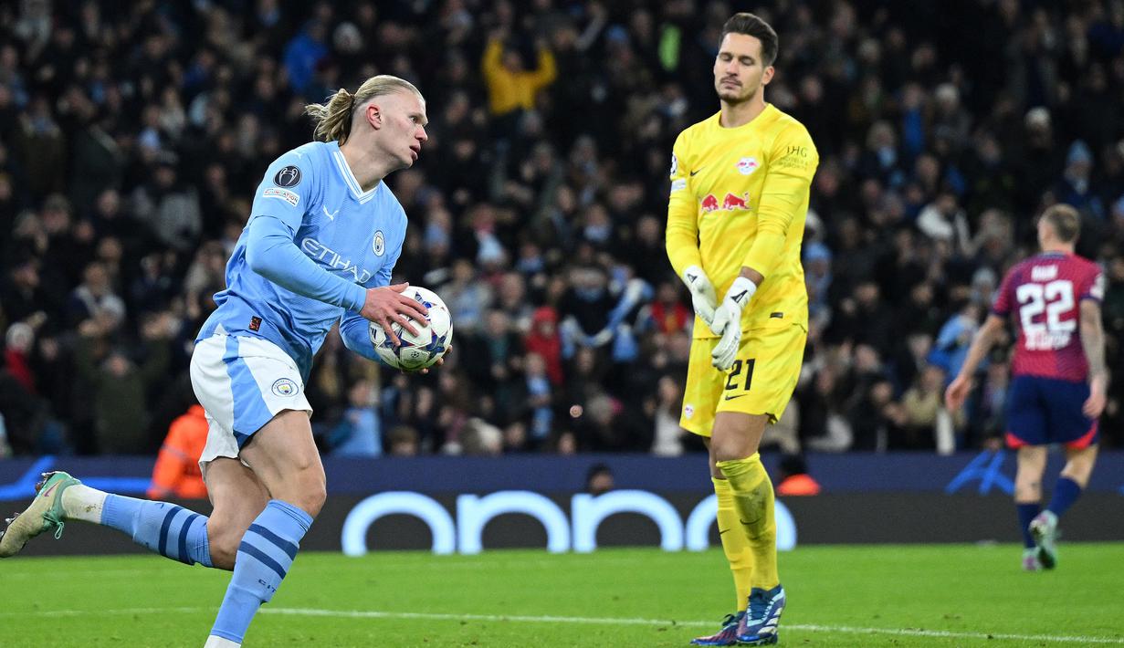 Pemain Manchester City, Erling Haaland memungut bola setelah mencetak gol ke gawang RB Leipzig pada laga lanjutan Grup G Liga Champions 2023/2024 yang berlangsung di Etihad Stadium, Manchester, Rabu (29/11/2023). (AFP/Paul Ellis)