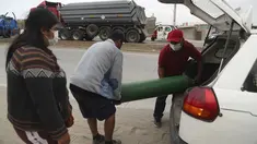 Orang-orang membawa tabung oksigen kosong dari mobil ke toko untuk mengisinya kembali di tengah pandemi COVID-19 di kawasan kumuh Villa El Salvador di Lima, Peru, Kamis (21/1/2021). Toko dibatasi untuk mengisi ulang hanya 20 tabung oksigen dalam sehari. (AP Photo/Martin Mejia)