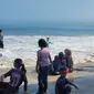 Para pengunjung liburan idul fitri 1445 H nampak menikmati sajian deburan ombak di kawasan wisata pantai Santolo, Garut,Jawa Barat. (Liputan6.com/Jayadi Supriadin)